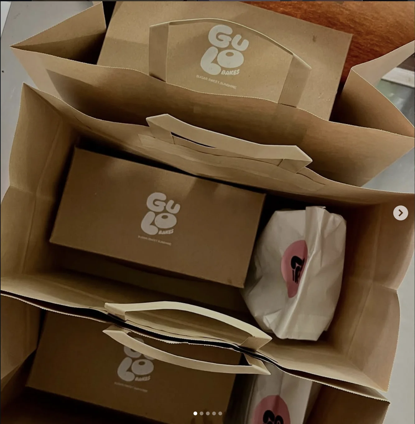 Project photograph of Gulo Bakes kraft packaging and bags bearing the rounded wordmark.